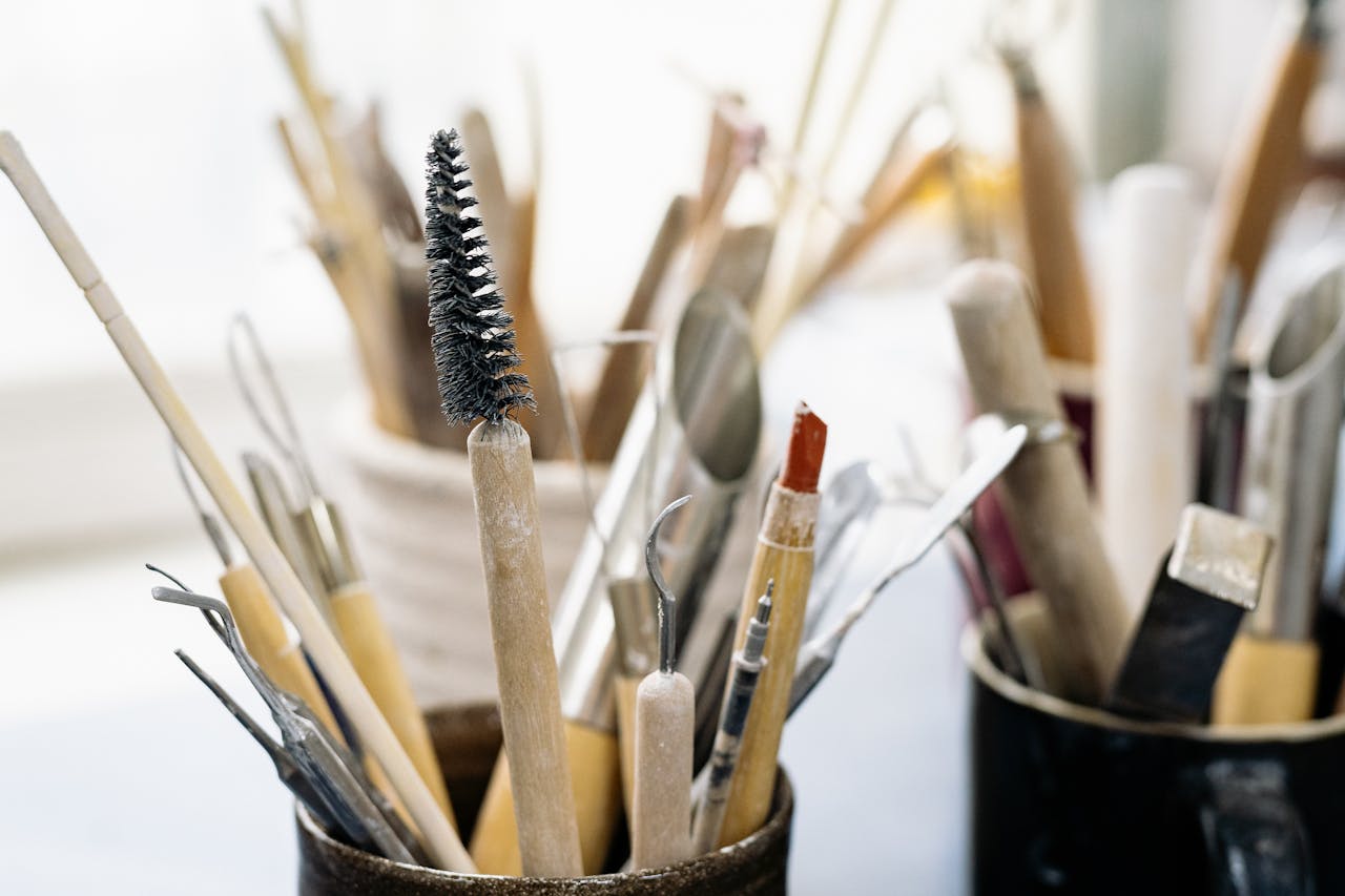 A close-up of various art and craft tools organized in cups, ideal for creative projects.